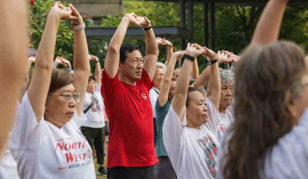 Sembawang Brisk Walking Movement Singapore residents doing group stretching exercise with Health Minister Ong Ye Kung leading fitness activity