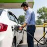 CNG Car Mileage Tips को दर्शाती इमेज जिसमें एक व्यक्ति CNG स्टेशन पर अपनी कार में गैस भरवाते हुए दिखाई दे रहा है।