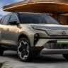 फ्यूचरिस्टिक डिजाइन वाली Tata Harrier EV इलेक्ट्रिक SUV चार्जिंग स्टेशन के पास खड़ी दिखाई दे रही है।