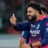 SRH vs RR Eliminator IPL 2026 में शानदार जीत के बाद राजस्थान रॉयल्स के कप्तान Riyan Parag बल्ला और हेलमेट उठाकर जश्न मनाते हुए दिखाई दे रहे हैं।