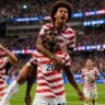 USA vs Paraguay World Cup मैच में गोल करने के बाद जश्न मनाते अमेरिकी खिलाड़ी, विश्व कप में अमेरिका की शानदार जीत का दृश्य।