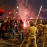 RCB IPL 2026 जीत के बाद सड़क पर जश्न मनाते और पुलिस द्वारा नियंत्रित किए जाते क्रिकेट फैंस का दृश्य।